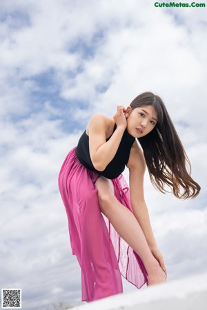 A woman in a pink lingerie leaning against a wall.