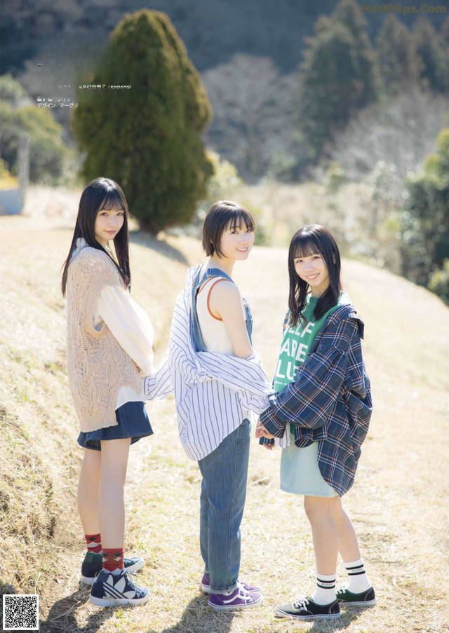 A group of young women standing next to each other in a field.