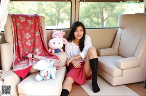 A woman in a red and black plaid skirt is sitting in a car.