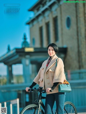 A woman in a black dress posing for a magazine.