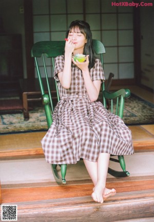 A woman sitting at a table with her hand on her chin.