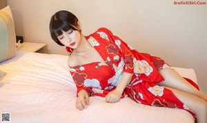 A woman in a red kimono standing in front of a door.