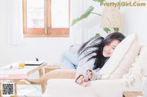 A woman sitting on a bed with her legs crossed.