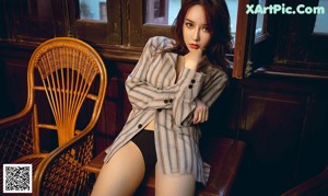 A woman sitting in a chair next to a piano.