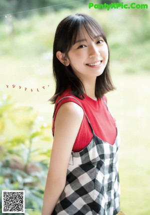 A woman in a white shirt is smiling at the camera.