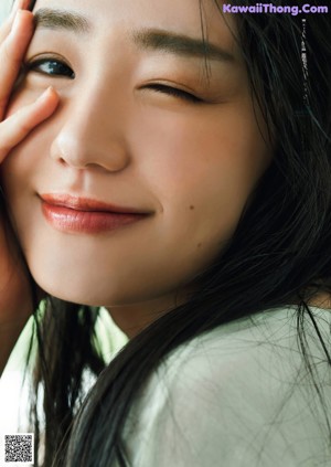 A woman with long black hair is posing for a picture.