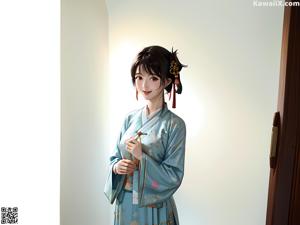 A woman in a white and gold kimono sitting on a chair.