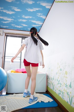 A woman in red shorts and a black top posing for a picture.