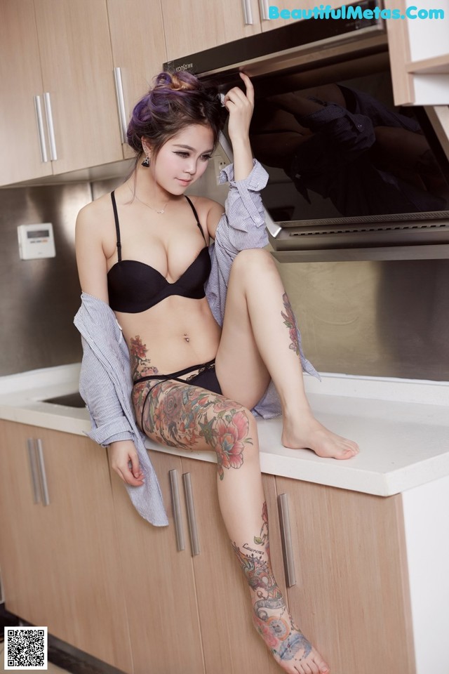 A woman sitting on top of a kitchen counter next to an oven.