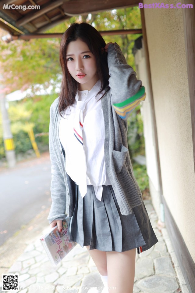 A young woman in a school uniform posing for a picture.