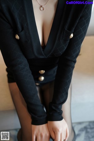 A woman in black stockings and high heels posing for the camera.