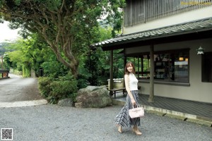 A naked woman in a kimono standing in a room.