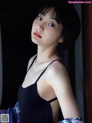 A woman laying on a bed in a blue kimono.