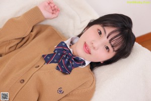 A woman in a school uniform is posing for a picture.
